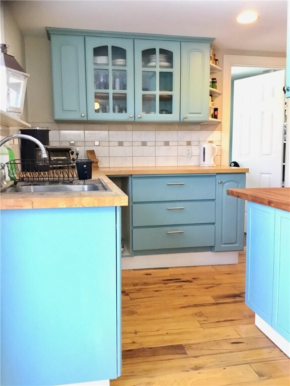 Kitchen with wood flooring. West facing window ove