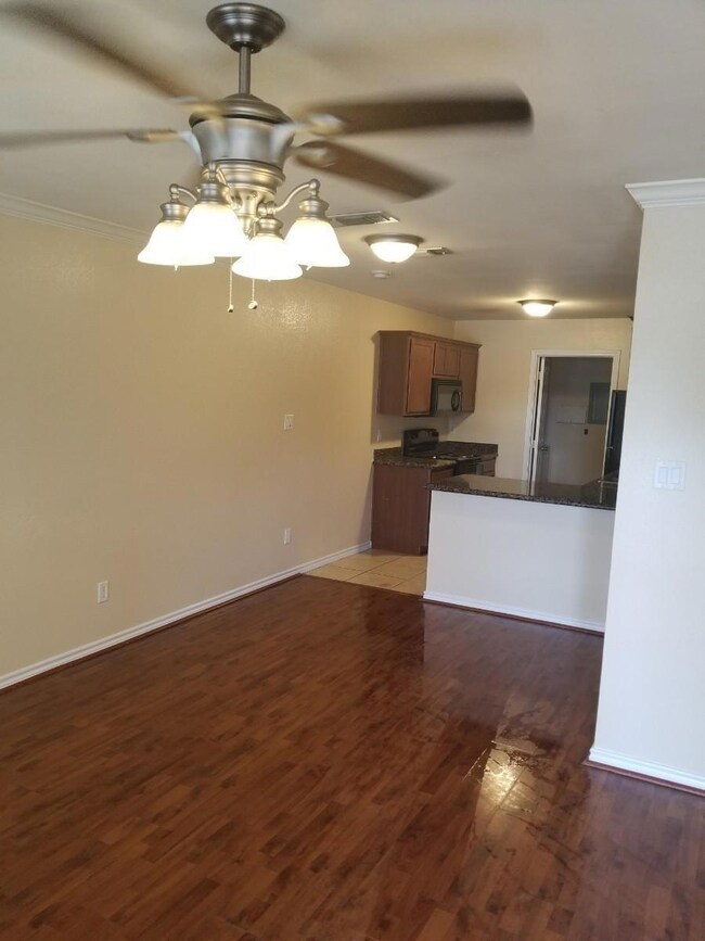 Empty room featuring ornamental molding, dark hard