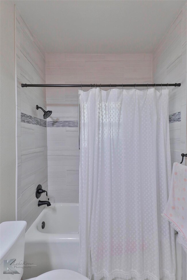 Bathroom featuring toilet and shower / tub combo