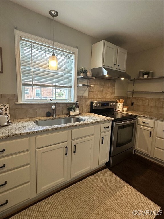 Kitchen with exhaust hood, a sink, white cabinets,