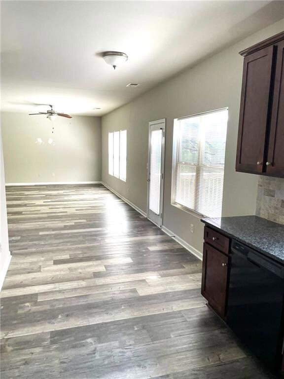 Kitchen with dishwasher, dark brown cabinets, a ceiling fan, wood finished floors, and open floor plan