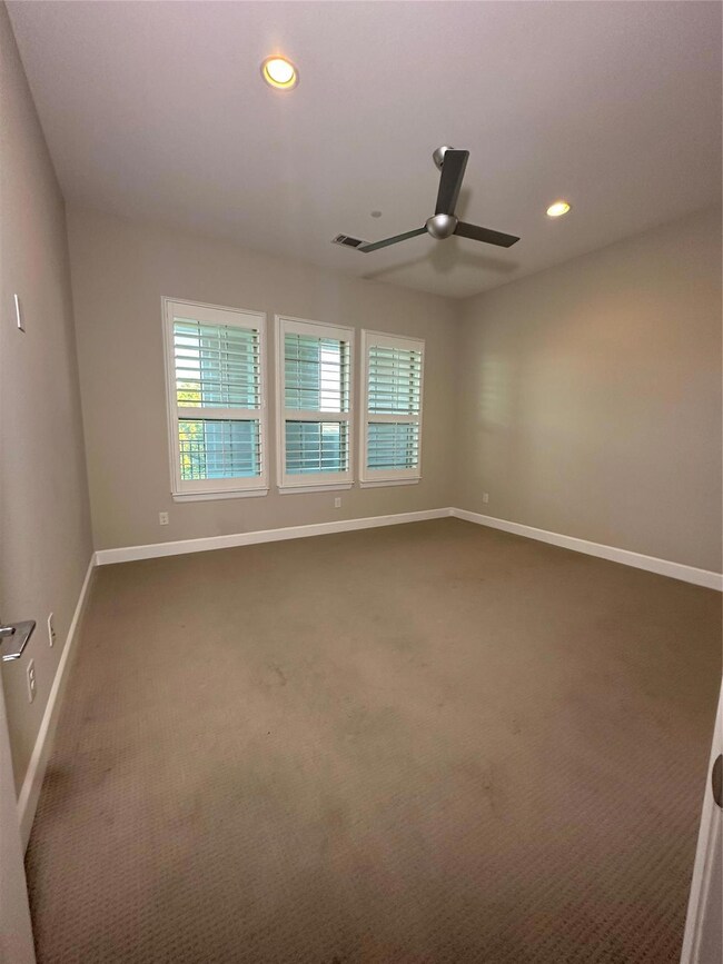 Carpeted spare room with ceiling fan