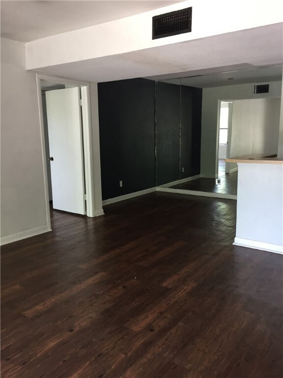 Empty room featuring dark hardwood / wood-style fl