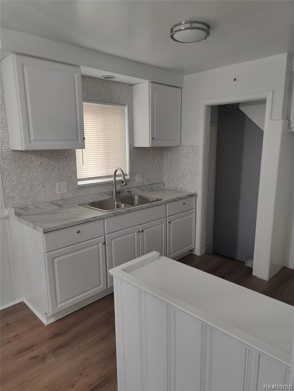 Kitchen with dark wood-style floors, light countertops, white cabinets, and backsplash