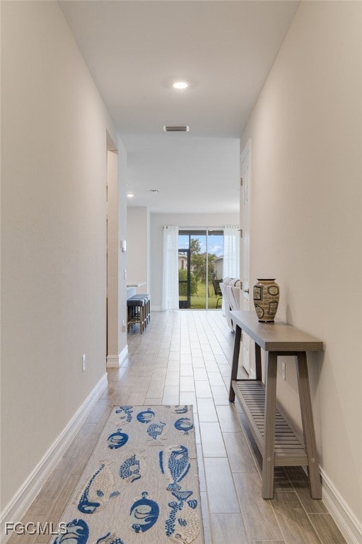 Hallway with baseboards and recessed lighting