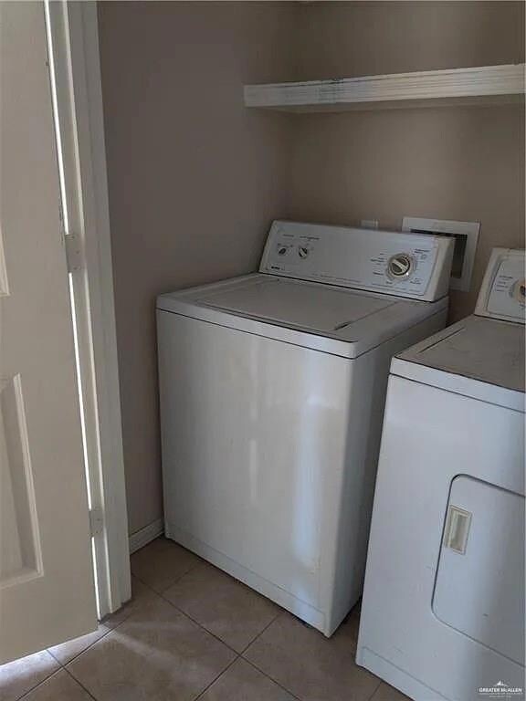 Laundry room featuring independent washer and dryer, laundry area, and light tile patterned floors