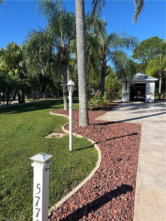 View of grassy yard featuring concrete driveway