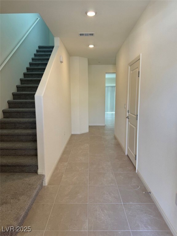 Hallway with stairs, visible vents, recessed light