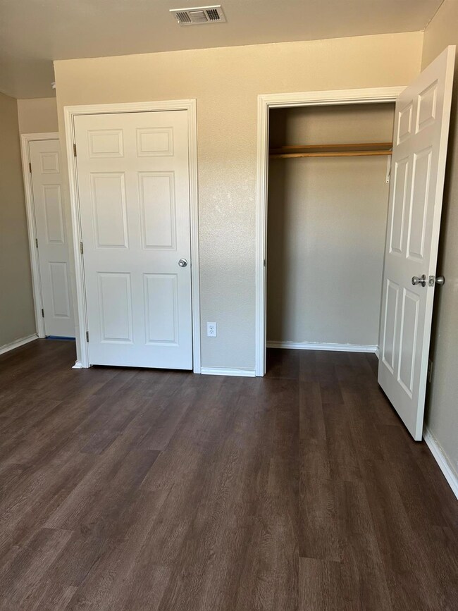 Unfurnished bedroom with dark wood-style floors a