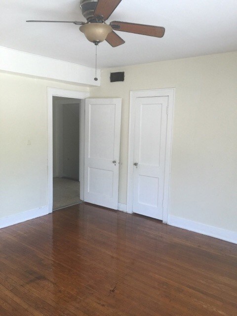 Unfurnished bedroom with dark wood-style flooring and a ceiling fan