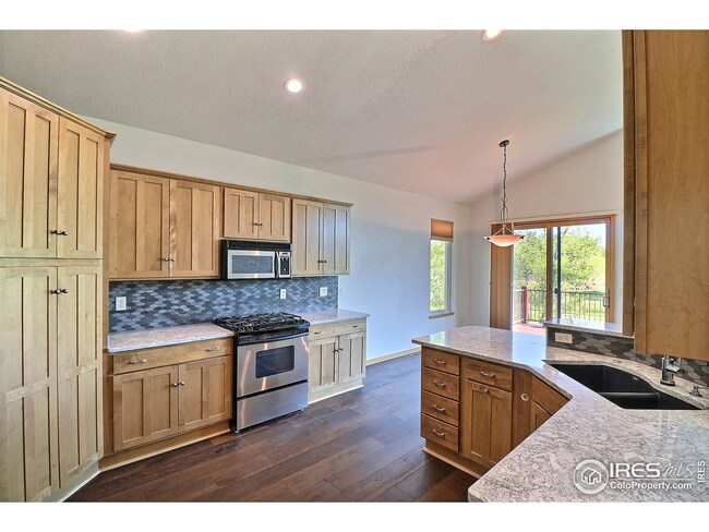 Gas range and microwave flanked by stone backsplash