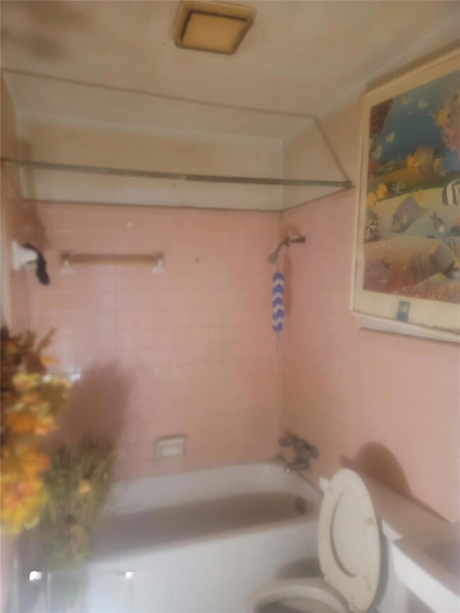 Bathroom featuring tiled shower / bath and toilet