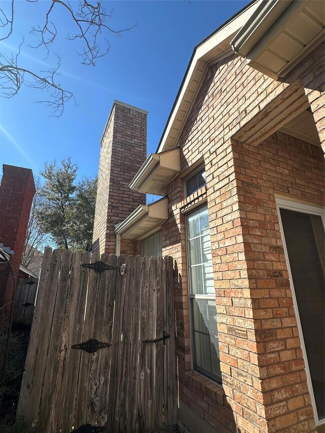 View of property exterior with brick siding, a chi