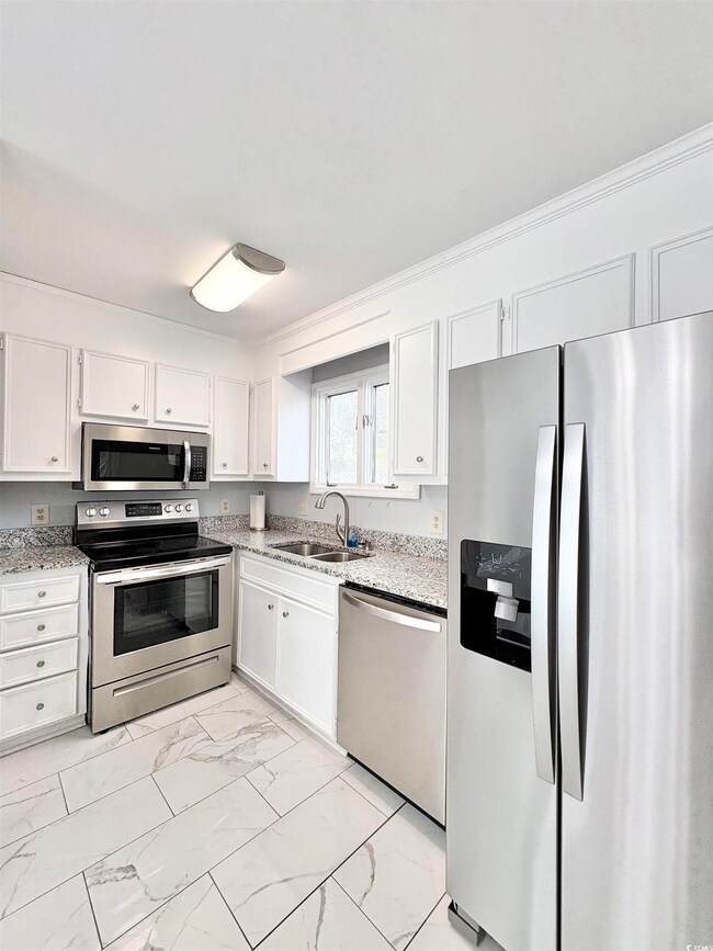 Kitchen featuring marble finish floor, a sink, whi