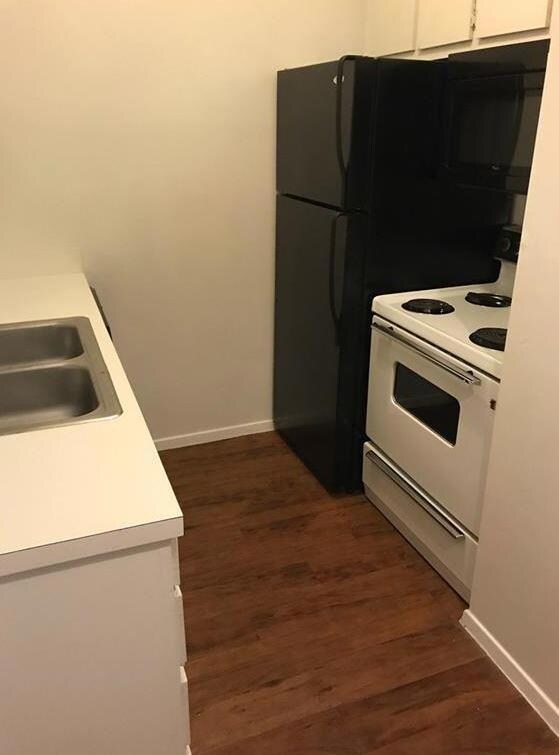 Kitchen with light countertops, white cabinets, e