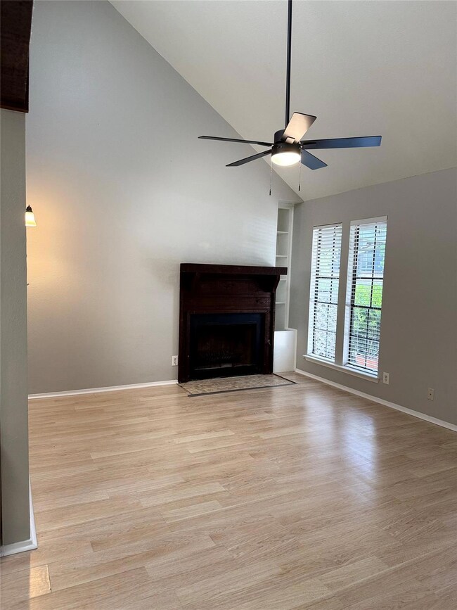 Unfurnished living room with ceiling fan, built i