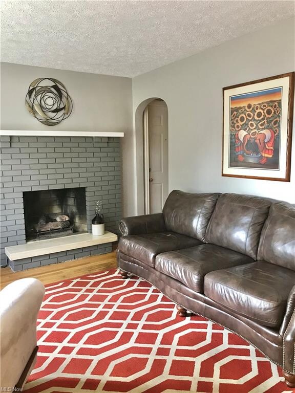 Living room with gas log fireplace, hardwood floor
