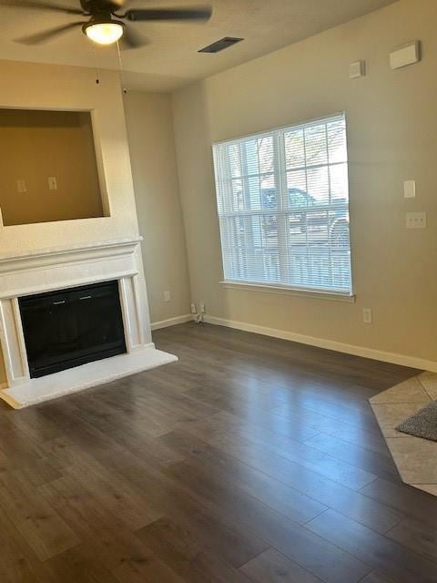 Unfurnished living room with a ceiling fan, a glas