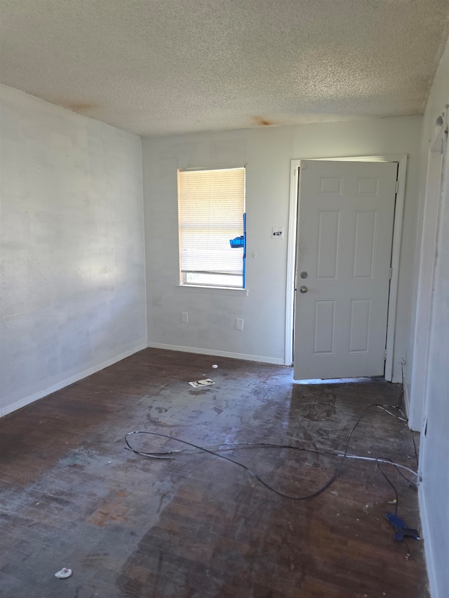 Foyer with baseboards and a textured ceiling