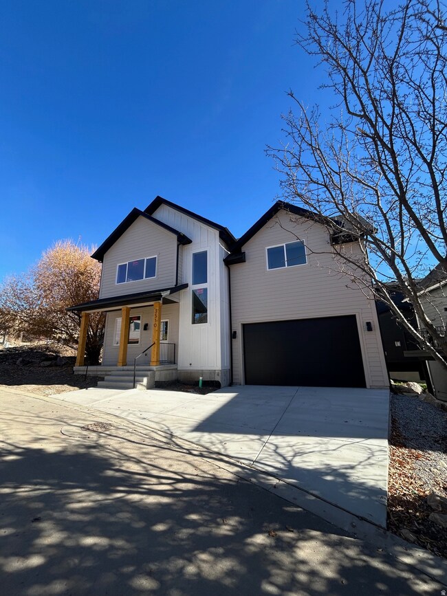 View of front of home with a porch, driveway, a garage, and board and batten siding