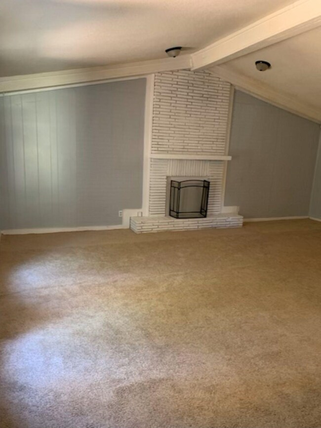 Unfurnished living room with a fireplace, carpet f