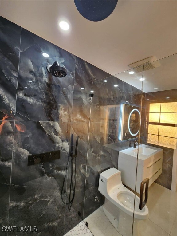 Bathroom with tiled shower, toilet, tile walls, va