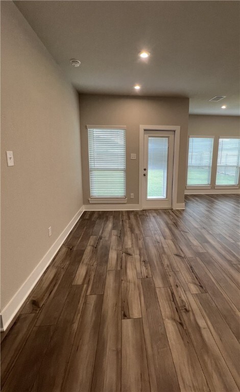 Unfurnished living room featuring dark wood finish