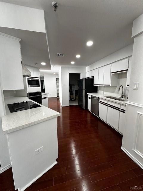 Kitchen featuring dark hardwood / wood-style flooring, refrigerator, white cabinets, sink, and dishwashing machine