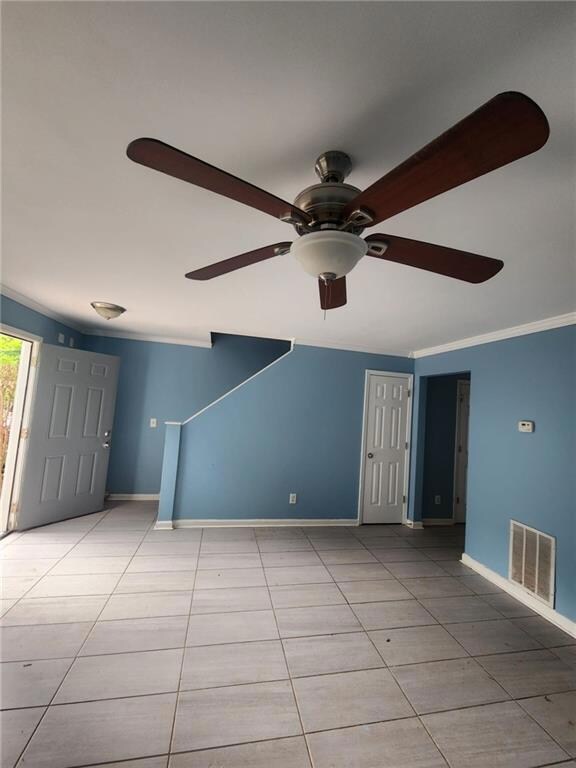 Spare room with crown molding, baseboards, a ceili