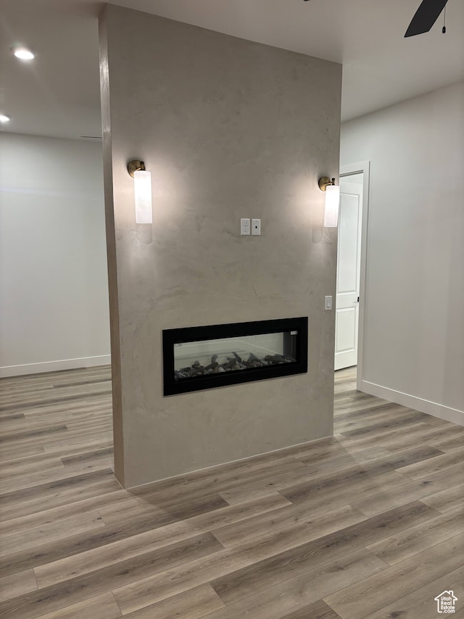 Primary Bedroom with fireplace, a ceiling fan, LVP Floors