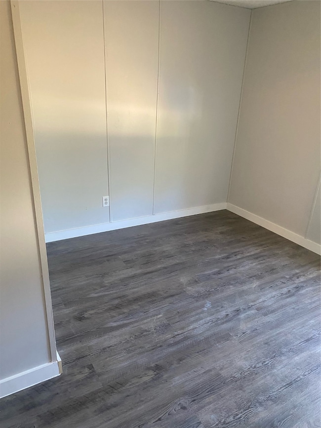 Spare room with dark wood-type flooring