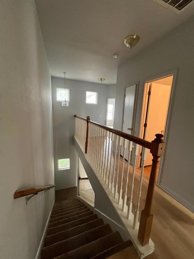 Staircase featuring baseboards and a chandelier