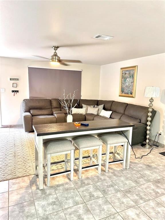 Living area featuring visible vents and a ceiling fan
