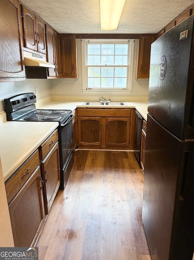 Efficient galley-style kitchen with full appliance package, double sink, and plenty of cabinet storage.