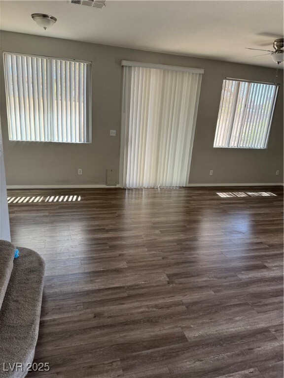 Spare room with dark wood-type flooring, visible v