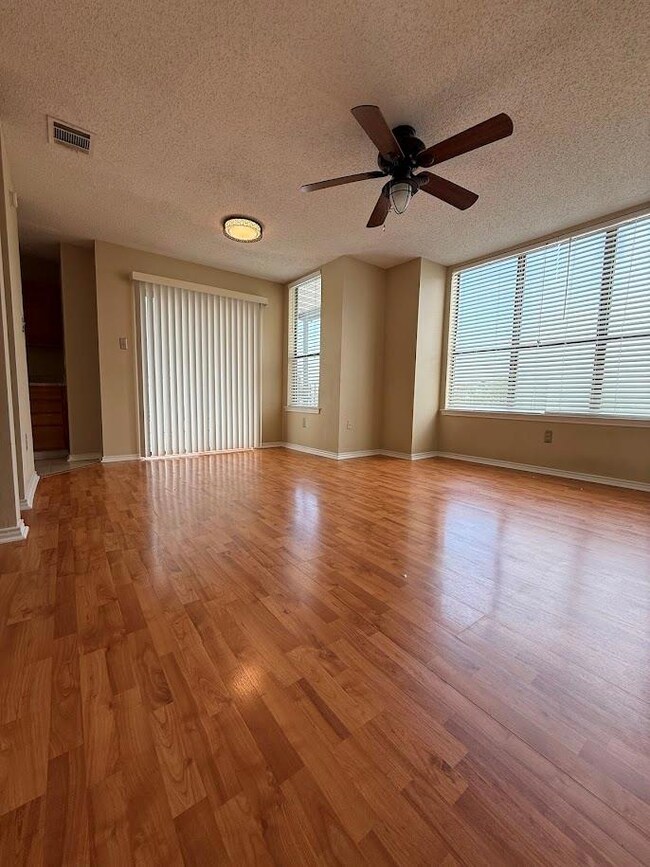 Empty room with a ceiling fan, wood finished floo