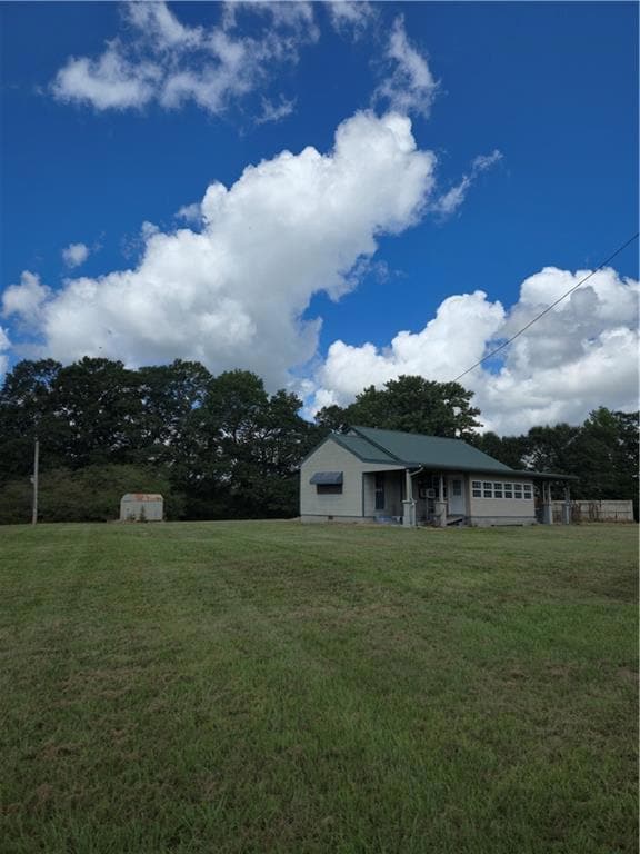 View of grassy yard featuring a shed