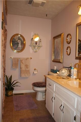 1 of 2 full baths down. Vinyl floors, linen closet, large vanity with lots of counter space and storage, tub/shower combo.