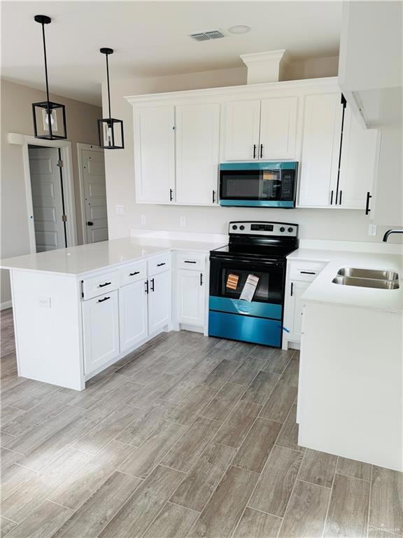 Kitchen with electric range oven, white cabinets, and wood tiled floors