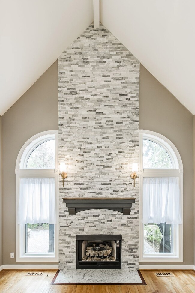 Gas log fireplace and impressive 18' brick mosaic tile surround, custom mantel.
