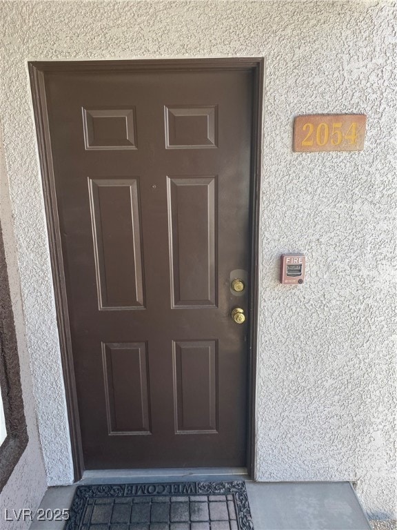 Doorway to property with stucco siding