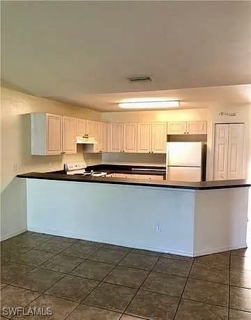 Kitchen with dark countertops, a peninsula, freest