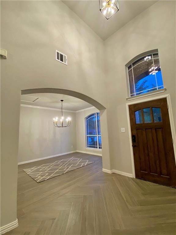 Entrance foyer with a towering ceiling, a chandel