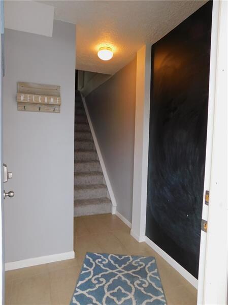 Entry has upgraded tile floor & chalk paint wall.