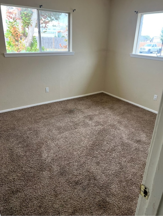 Bedroom featuring carpet and baseboards