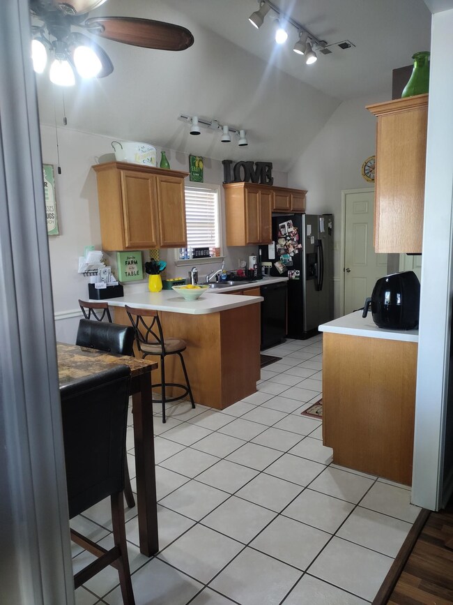 Kitchen featuring ceiling fan, a breakfast bar are