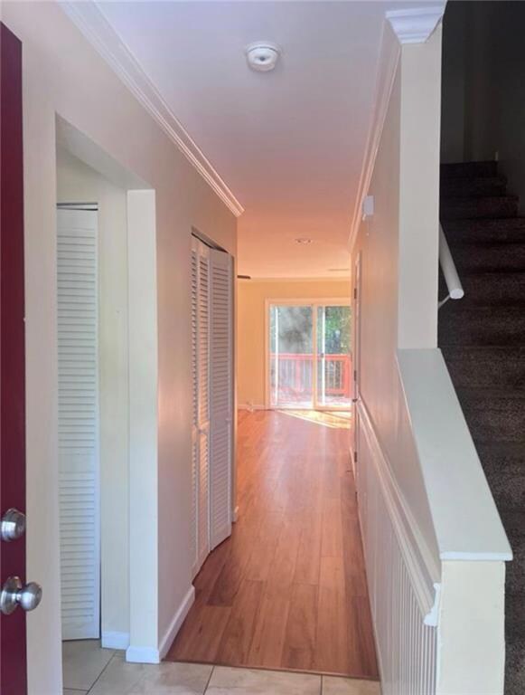 Corridor with ornamental molding, baseboards, and 