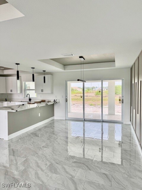 Kitchen with a raised ceiling, light countertops,