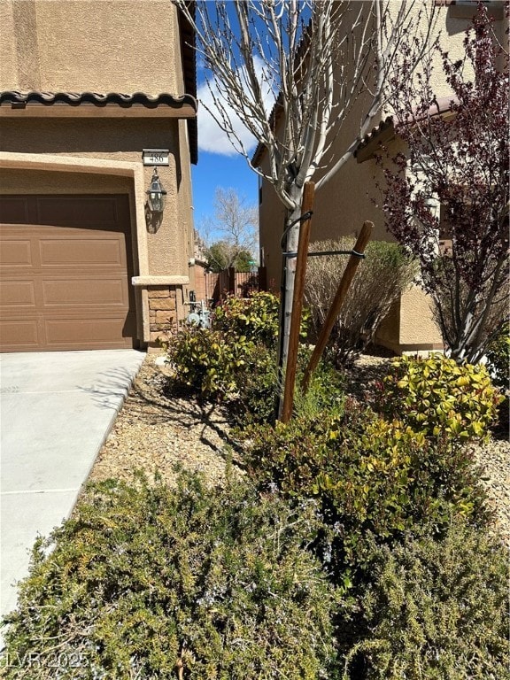 View of property exterior with concrete driveway,