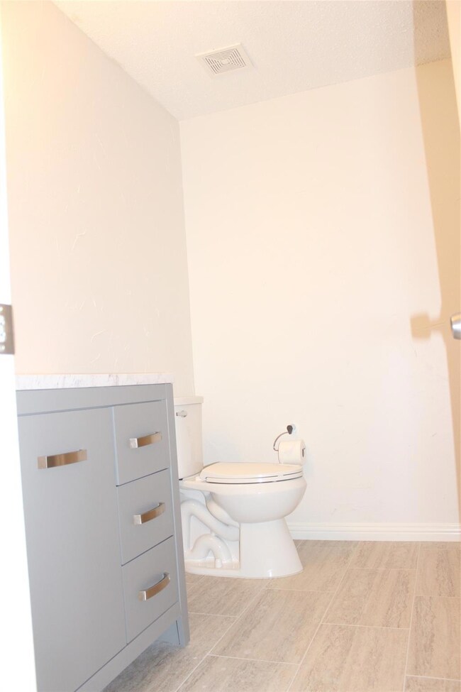 Bathroom with tile floors, vanity, and toilet
